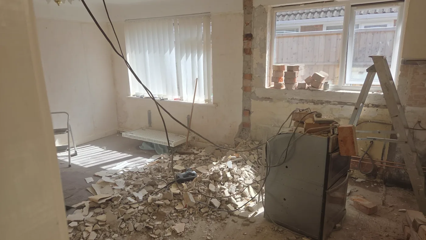 The same room during the build, stripped back to brick and plaster with the dividing wall opened up.