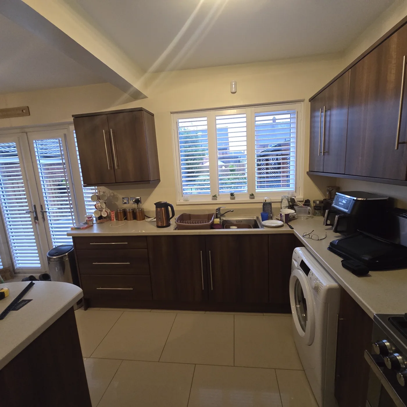 The original dark wood kitchen, with the old sink and window shutters.